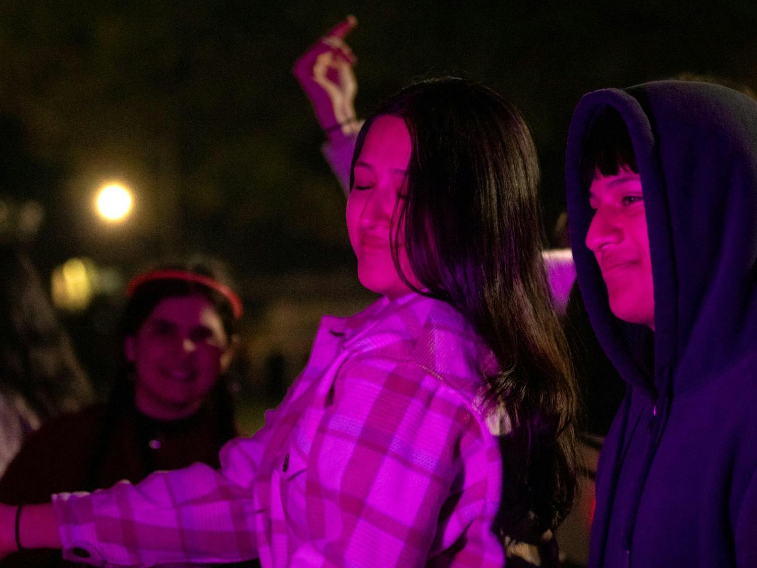 Fourth-year political science student Citlaly Rojo dances alongside her brother, John Rojo, who visited her to attend Tiger Burn on Nov. 20, 2023. The university provided shuttles to transport students to and from the event from the Horseshoe. 