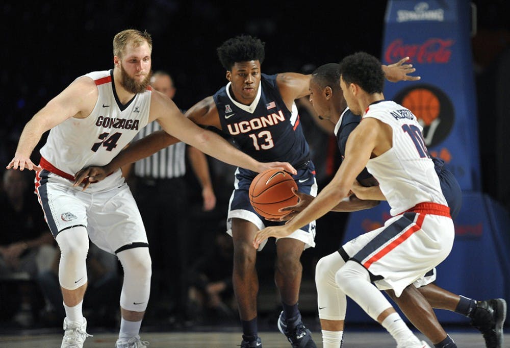 Gonzaga Bulldogs center Przemek Karnowski (24), left, and Connecticut Huskies forward Steven Enoch (13) look on as Connecticut Huskies guard Sterling Gibbs (4) scoops up a loose ball in front of Gonzaga Bulldogs guard Bryan Alberts (10) during the third/fourth place game of the Battle 4 Atlantis on Friday, Nov. 27, 2015, in Nassau, Bahamas. (Brad Horrigan/Hartford Courant/TNS)