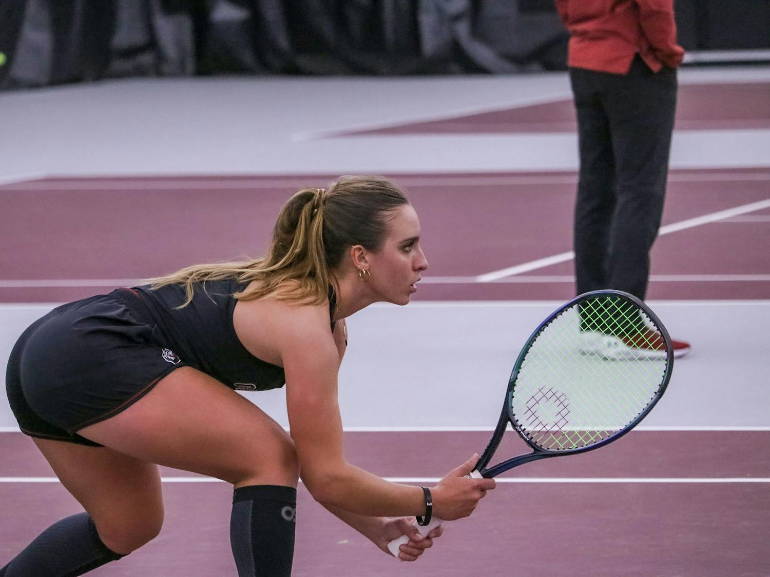 Senior Ana Cruz lowers her stance as her partner, junior Allie Gretkowski, powers up for a strong serve against Yale on Feb. 17, 2023. The duo defeated the Bulldogs 6-2 in their set. 