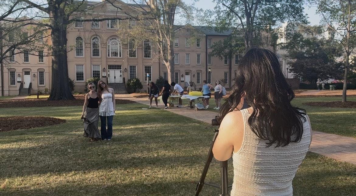 Third-year visual communications student Grayson Edwards photographs fourth-year retailing students Caroline Kelly (left) and Regan Dowdy (right) for the Sustainability Photoshoot hosted by Fashion Board and Sustainable Carolina on March 23, 2026.