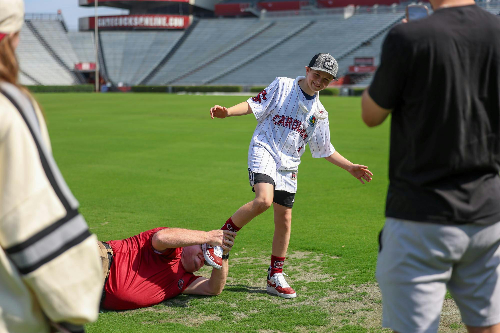 Lexington resident Gabriel Lyons is play-tackled by his dad while touring the fields at Williams-Brice Stadium on April 25, 2026. Lyons and his family toured the stadium and other athletics venues before Gabriel threw the first pitch at the baseball game between USC and Kentucky.