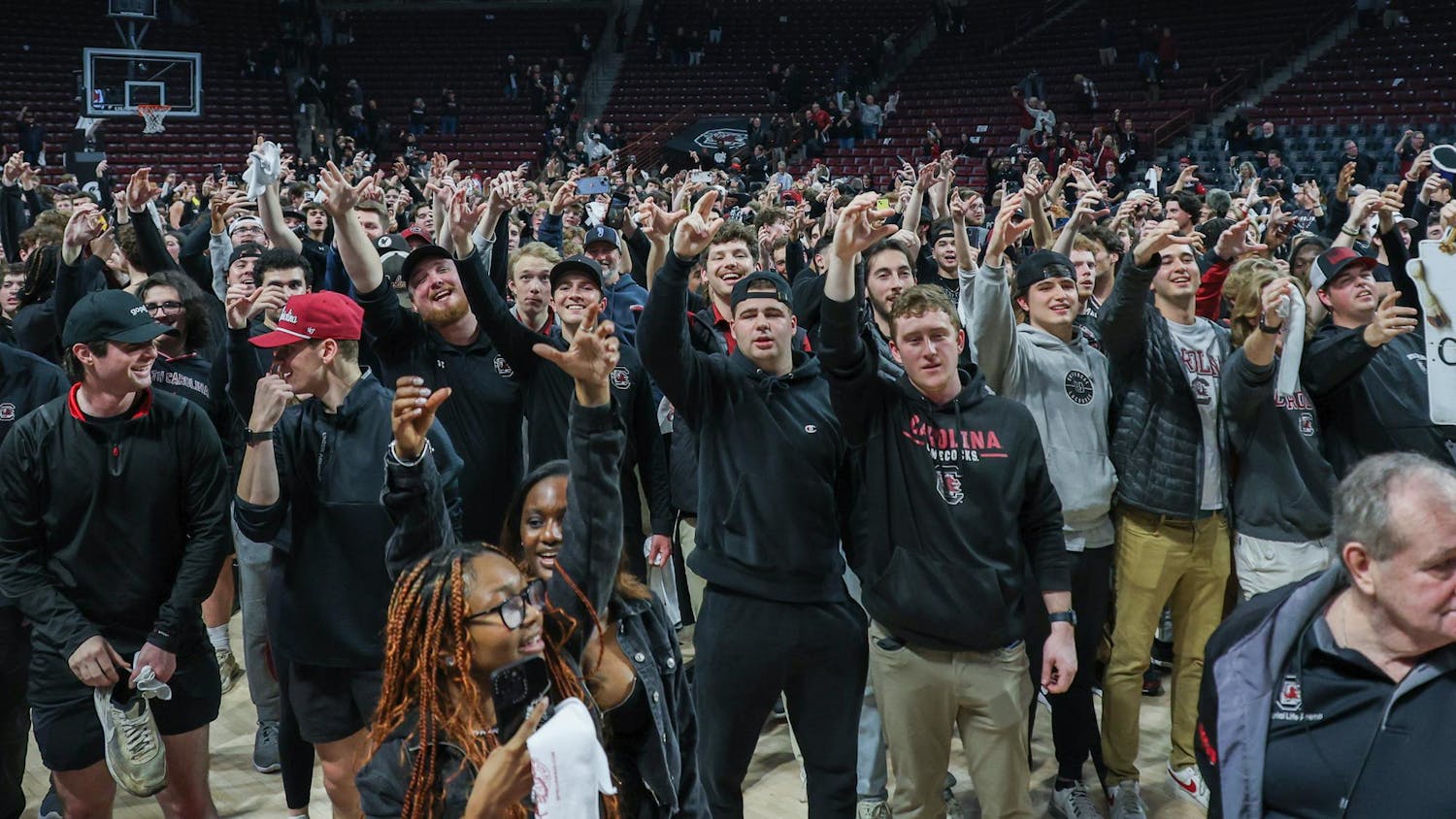 FILE- Gamecock fans raise their arms as a toast to South Carolina while the Carolina Band plays the alma mater following the men's basketball victory over Kentucky on Jan. 23, 2024. The Gamecock men's and women's basketball teams are participating in the NCAA Tournament this year as the No. 6 and No. 1 seeds, respectively.