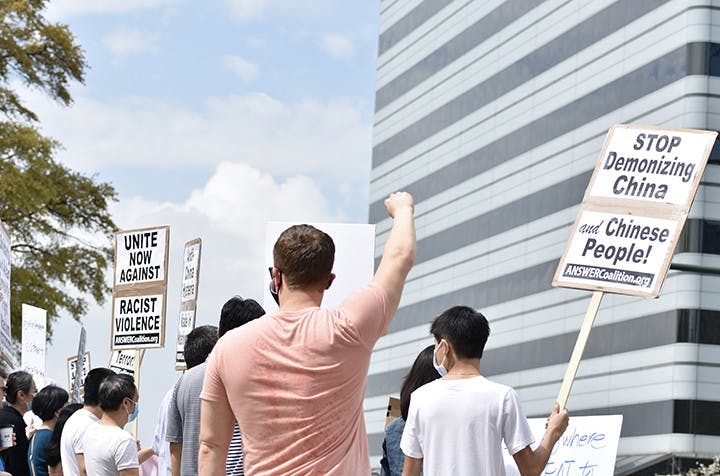  A protestor holds up a fist in solidarity with other protestors. 
