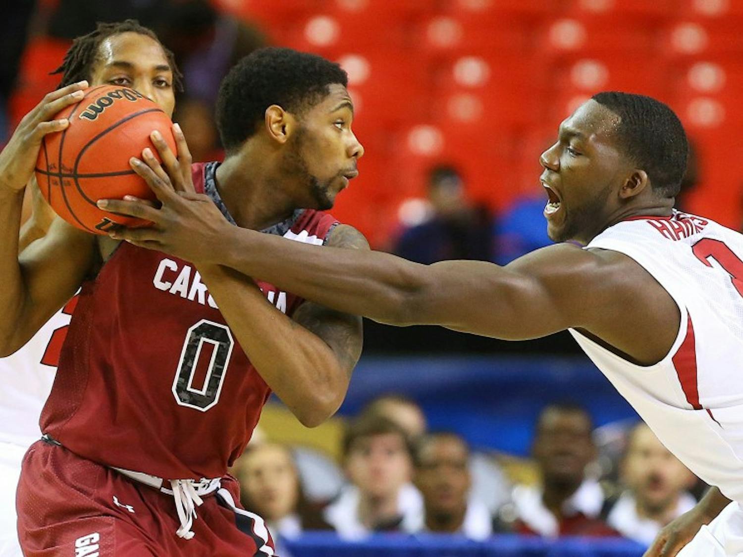 South Carolina's Sindarius Thonwell (0) works against Arkansas' Alandise Harris during the second half in the second round of the SEC Tournament on Thursday, March 13, 2014, at the Georgia Dome in Atlanta. South Carolina advanced, 71-69. (Curtis Compton/Atlanta Journal-Constitution/MCT)