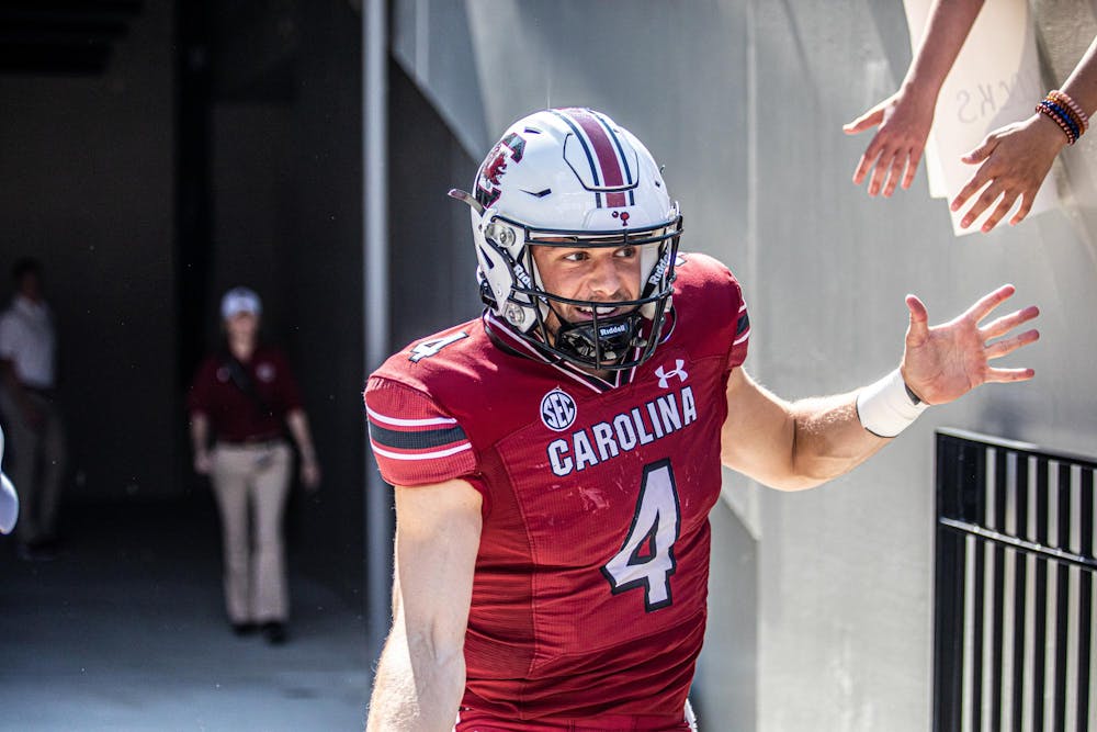 <p>FILE — Redshirt senior quarterback Luke Doty high-fives fans while running out of the tunnel before the Troy football game on Saturday, Oct. 2, 2021. Doty has been playing as a wide receiver for the Gamecocks in the 2023 season, changing his impact on the team.</p>