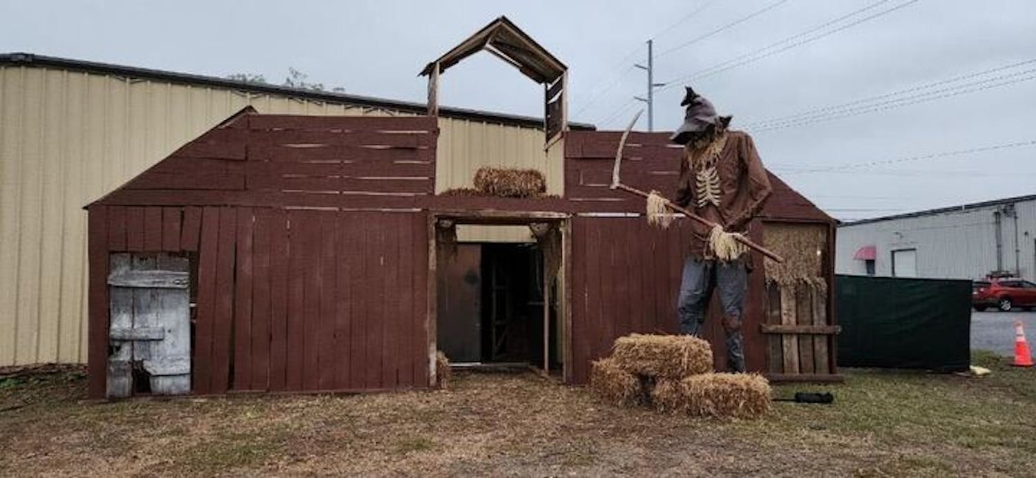 A large, scythe-wielding scarecrow towers over the entrance of the Hall of Horrors attraction in Cayce, South Carolina, throughout October 2023. A portion of the proceeds raised at the attraction goes to Camp Hope, a summer camp for people with cognitive disabilities.