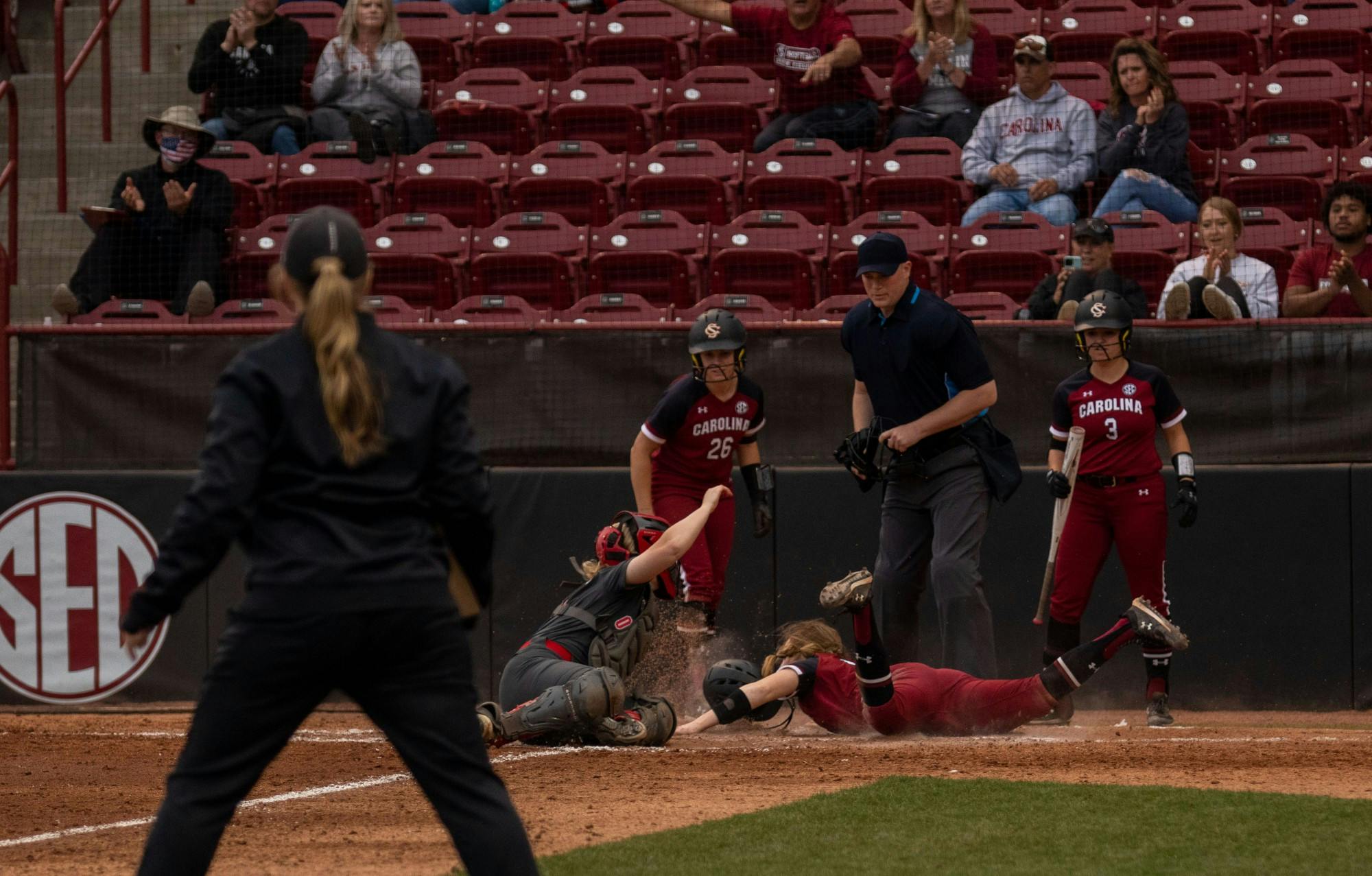 Freshmen Emma Sellers, crashes into umpire in an attempt to beat the ball to home plate in the fifth inning against Ohio State on Feb. 26, 2022, at Beckham Field. Carolina lost in their third game of the Carolina Classic against Ohio State 6-2. 