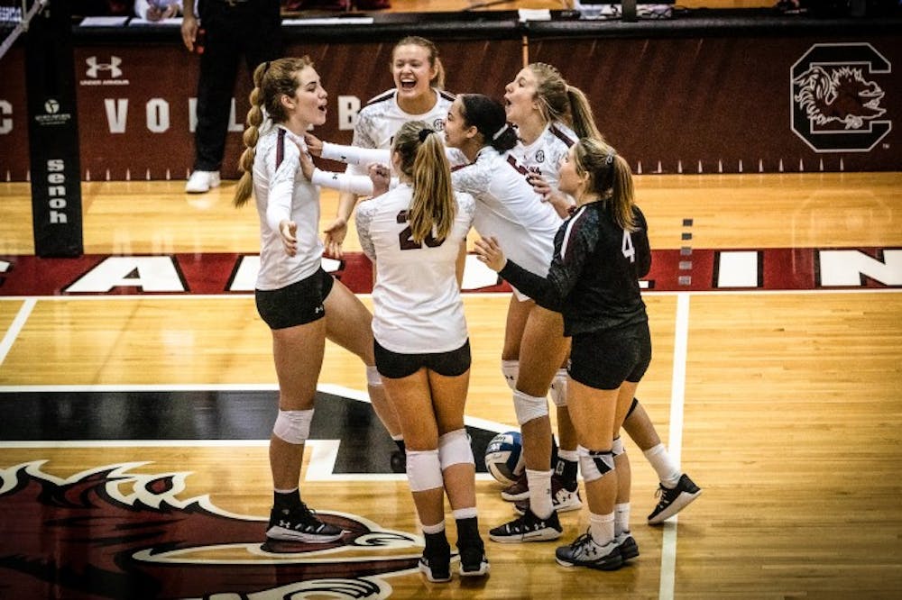 Members of the South Carolina volleyball team celebrate after scoring against Ole Miss.