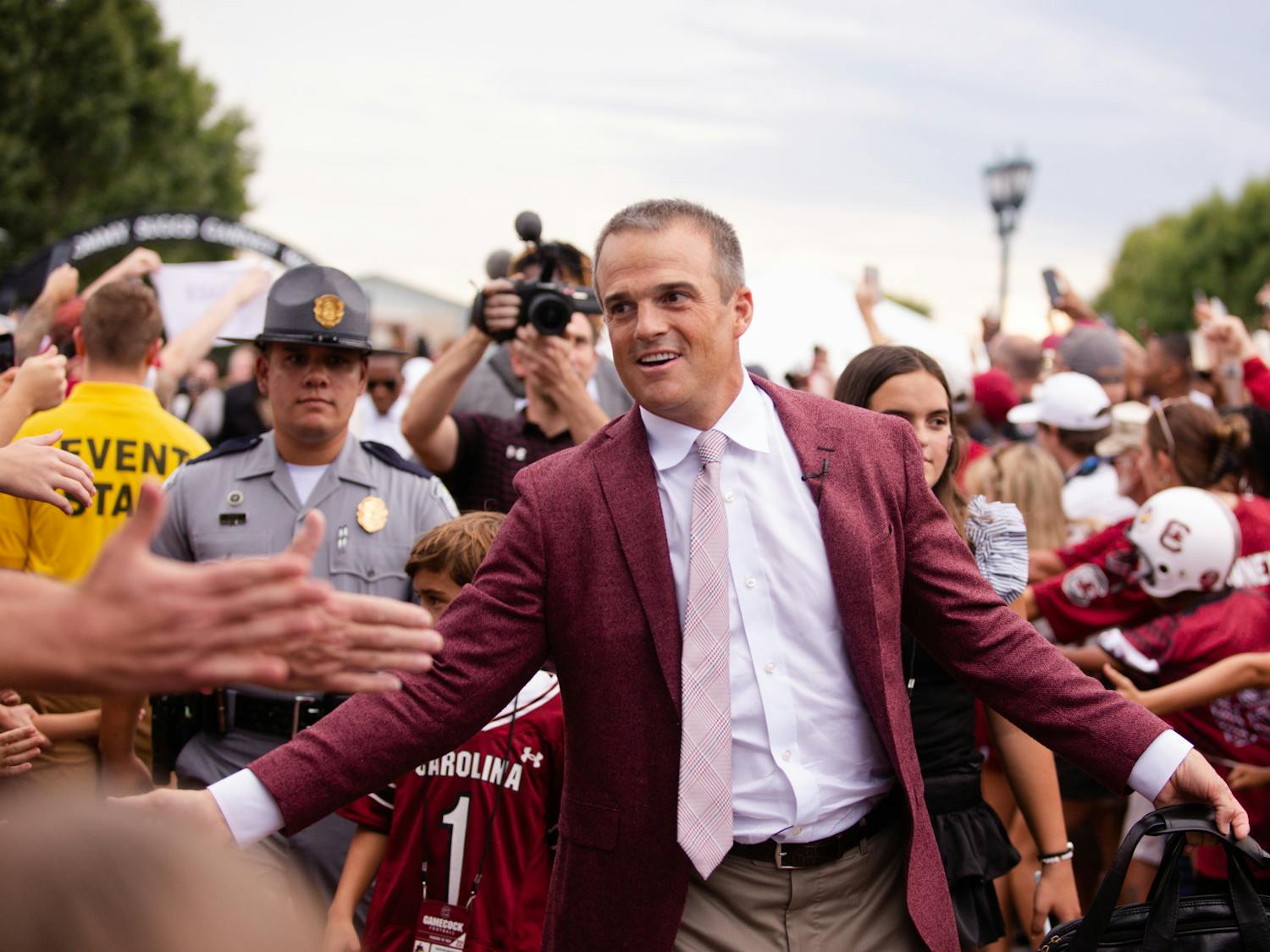 FILE—Head football coach Shane Beamer high-fives fans while walking into Williams-Brice Stadium on Sept. 3, 2022. Beamer led his team to a 35-14 win against Georgia State.&nbsp;