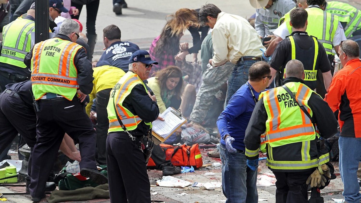 Emergency personnel assist the victims at the scene of a bomb blast during the Boston Marathon in Boston, Massachusetts, Monday, April 15, 2013. (Stuart Cahill/Boston Herald/MCT)