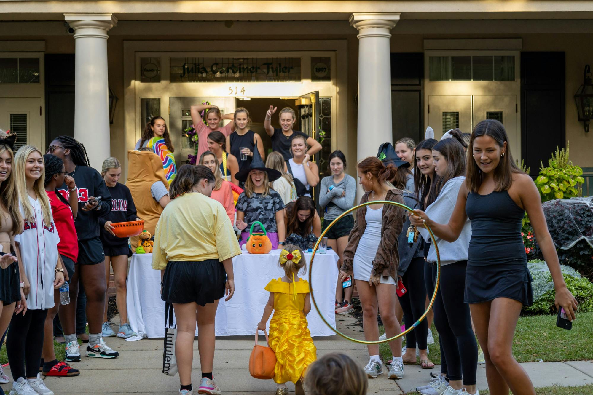 Members of a USC sorority stand outside of the sorority house entertaining costumed trick or treaters with games and toys on Oct. 25, 2022. USC Greek fraternities and sororities played games and hosted fun activities for children as they approached each candy table.