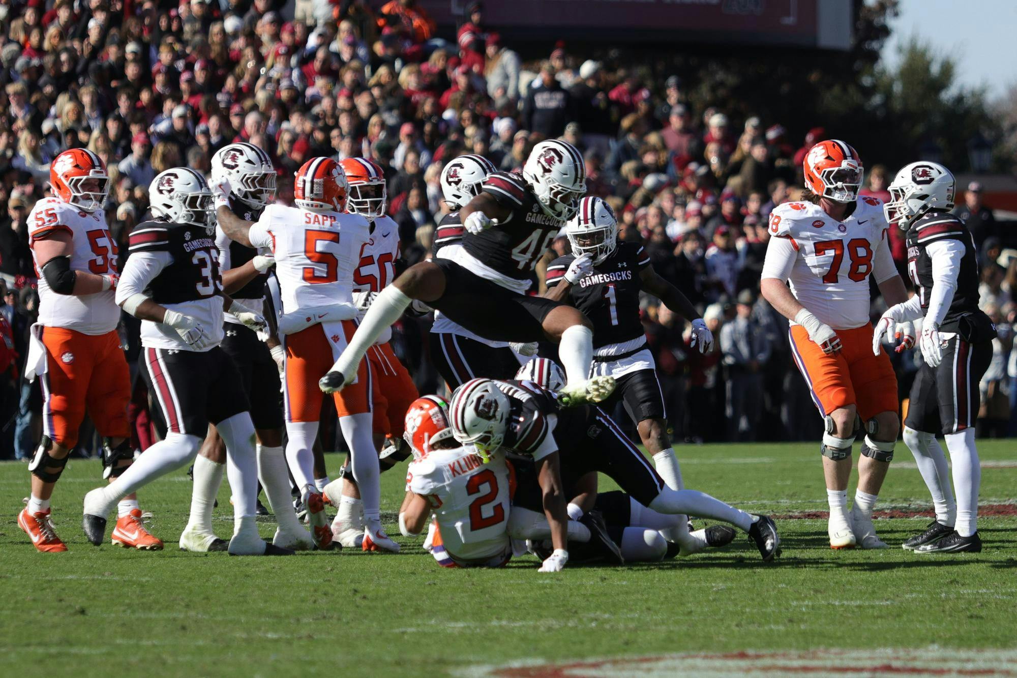 Senior EDGE Bryan Thomas Jr. leaps over the pile as South Carolina defenders bring down a Clemson quarterback during South Carolina’s game against Clemson at Williams-Brice Stadium on Saturday. The play stopped the Tigers’ progress as the Gamecocks’ defense swarmed the backfield.