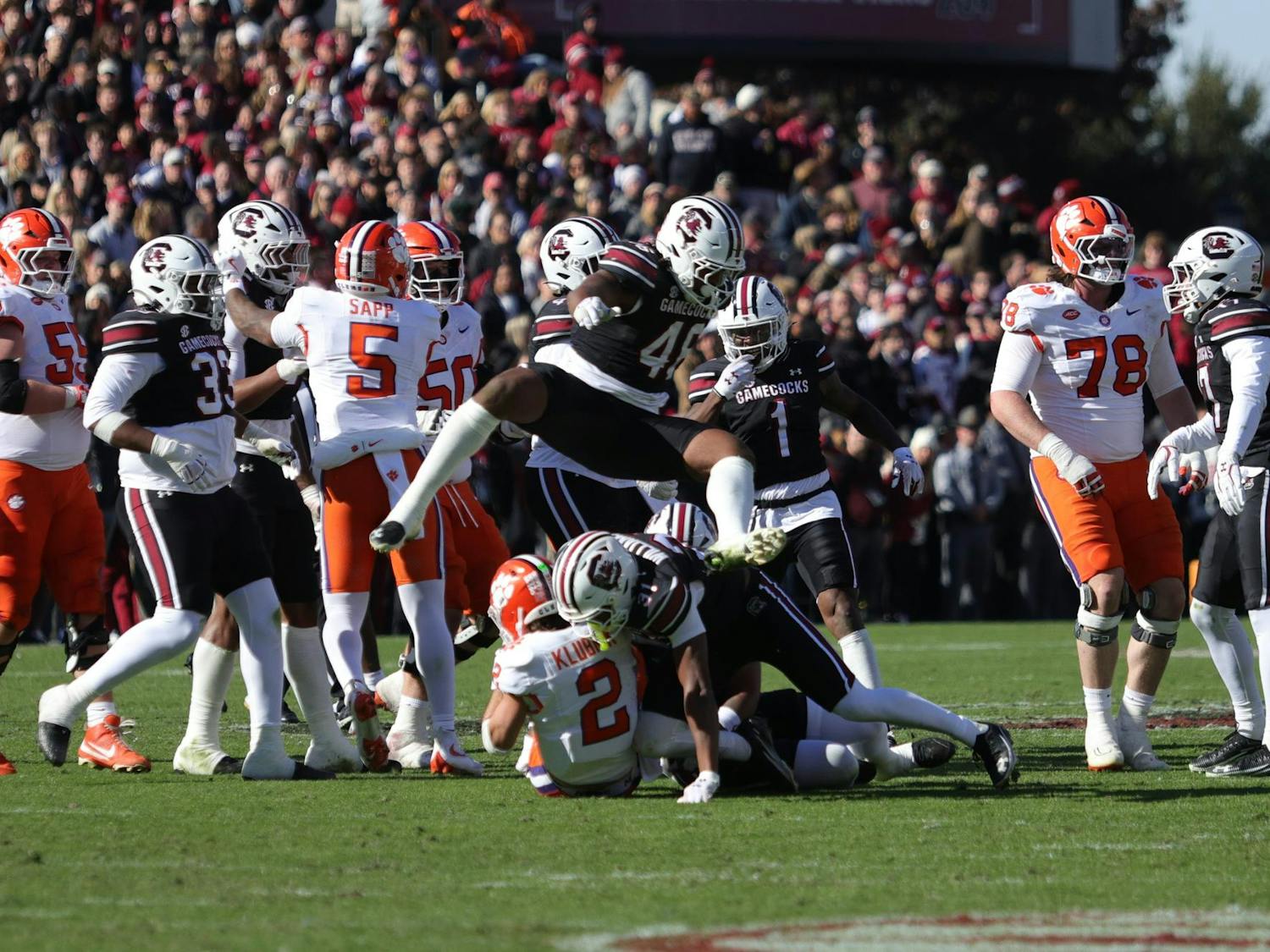 Senior EDGE Bryan Thomas Jr. leaps over the pile as South Carolina defenders bring down a Clemson quarterback during South Carolina’s game against Clemson at Williams-Brice Stadium on Saturday. The play stopped the Tigers’ progress as the Gamecocks’ defense swarmed the backfield.