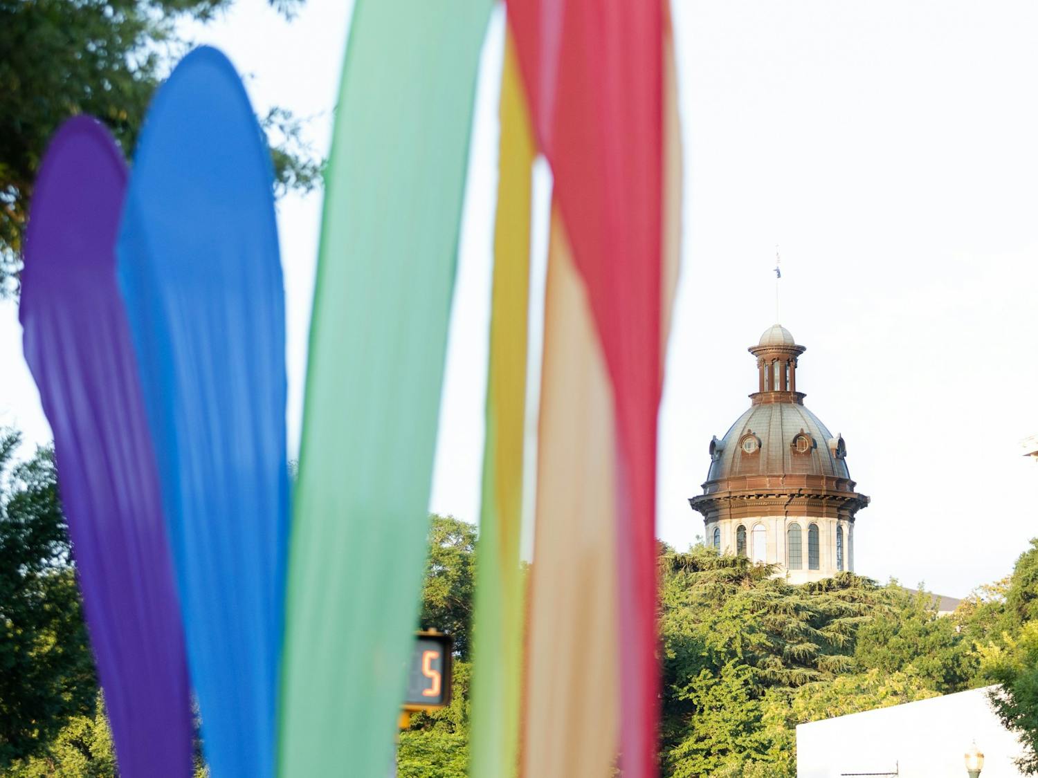 A picture of rainbow banners in front of the statehouse on June 4, 2022. The banners marked the location of Outfest, a showcase that focused on the LGBTQIA+ community with local vendors, businesses and talent during national Pride month.