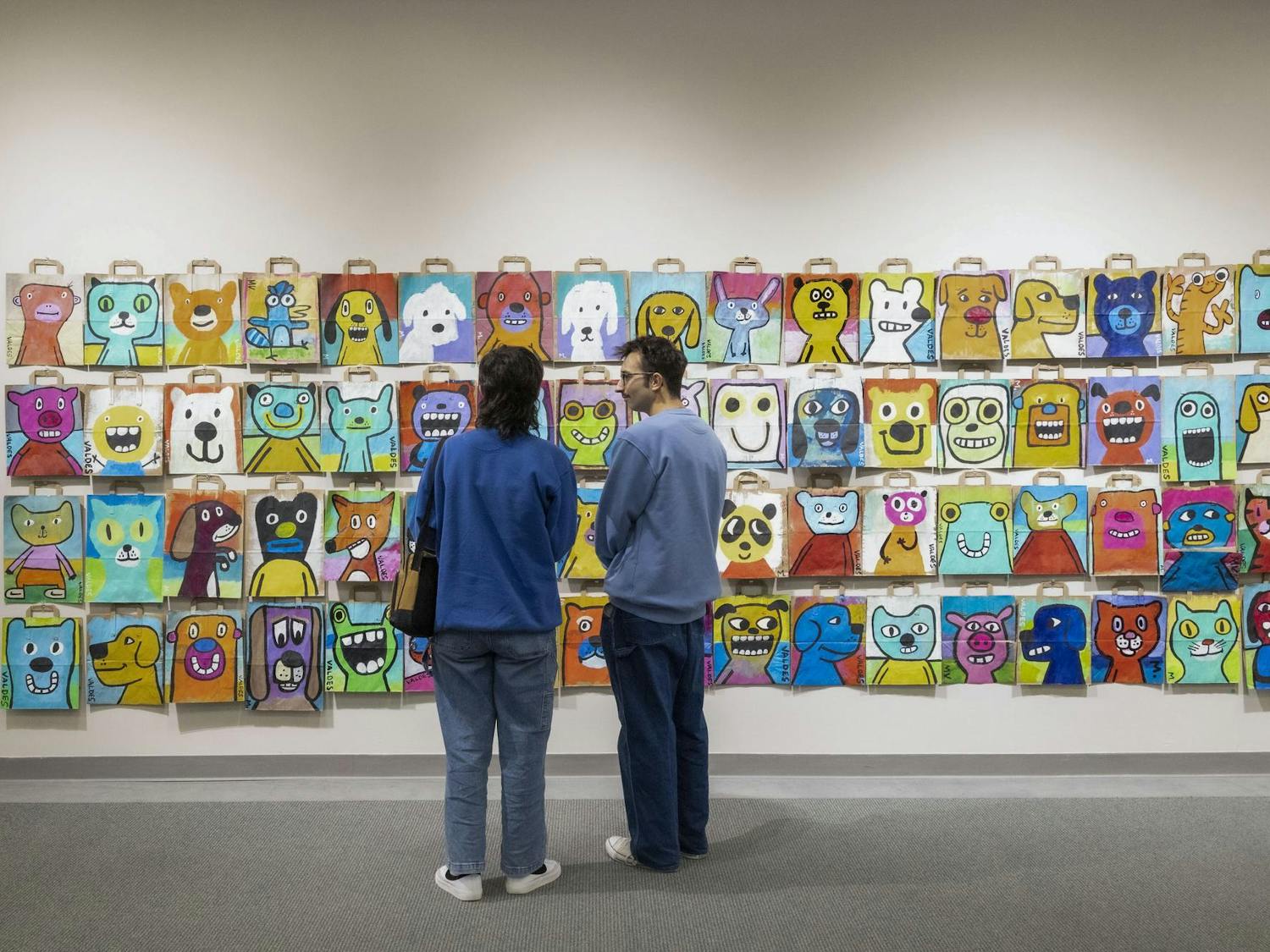 Patrons stand viewing the "Joyous Creatures" exhibit in the Upstairs Gallery of the Koger Center for the Arts, a collection created to be simple and bring joy to its viewers. The exhibit opened on Dec. 1, 2023, and features more than 200 pieces by USC School of Visual Art and Design professor Marius Valdes.