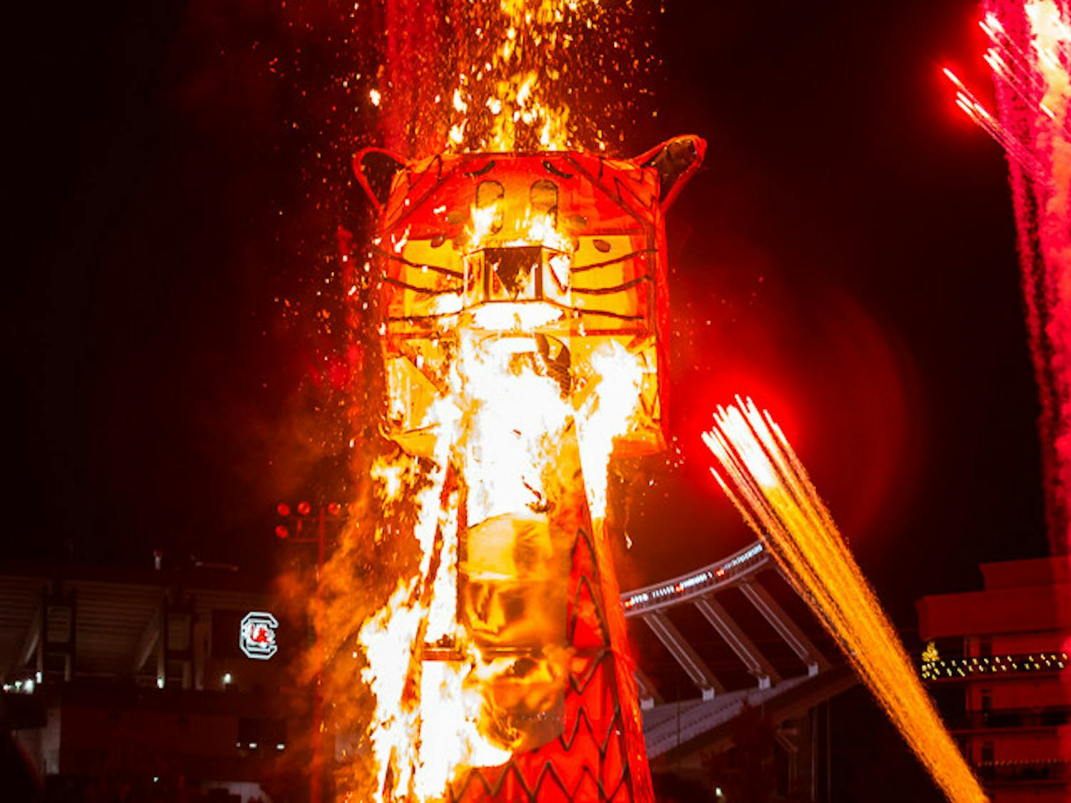 The blaze begins as the flames quickly catch and spread throughout the 32.5-foot-tall Celmson Tiger Statue. Fireworks are set off in the background for added effect.