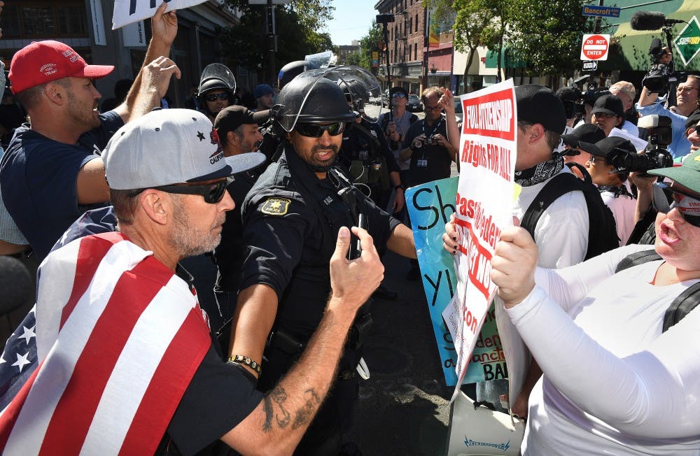 A police officer seperates both political sides as they argue before a speech by Milo Yiannopoulos in Berkeley, Calif., on Sunday, Sept. 24, 2017. (Wally Skalij/Los Angeles Times/TNS)