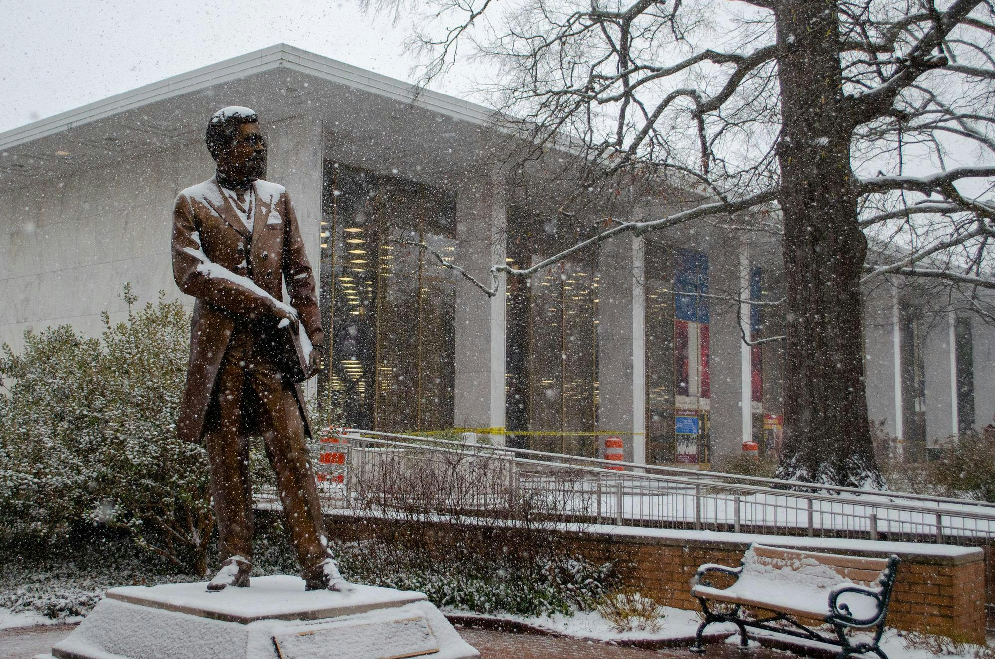 The Richard T. Greener statue, covered in snow, stands in front of the Thomas Cooper Library on Jan. 31, 2026. The library is operating under modified hours, but remains open.