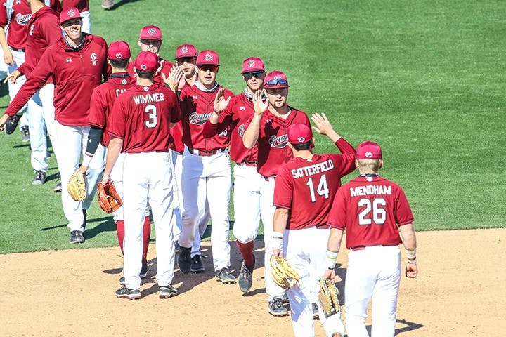 The South Carolina baseball team exchanges high fives after a game.