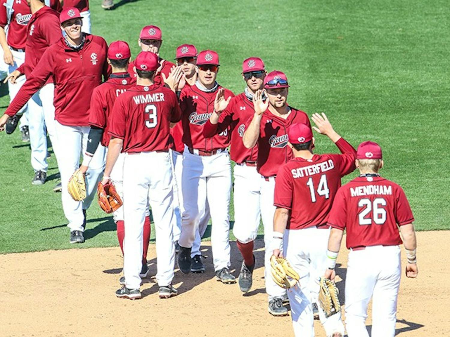 The South Carolina baseball team exchanges high fives after a game.
