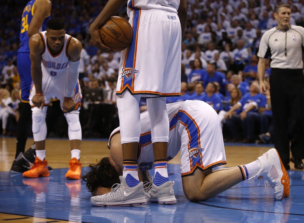 Oklahoma City Thunder's Steven Adams (12) kneels on the ground after being kicked by Golden State Warriors' Draymond Green (23) during the second quarteron Sunday, May 22, 2016, at Chesapeake Energy Arena in Oklahoma City. (Nhat V. Meyer/Bay Area News Group/TNS)