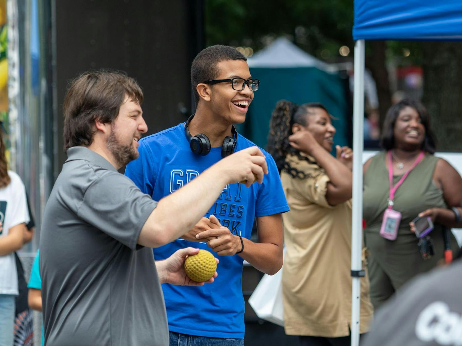 A participant with a City of Columbia volunteer prepares to throw the ball at the dunk booth at Soda City Market on July 27, 2024. Participants were able to throw different amounts of balls depending on how much money they donated to Sistercare Saturdays.