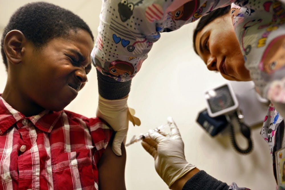 Desmond Sewell, 12, receives his vaccinations, including for TDAP against pertussis, or whooping cough, from Medical Assistant Jessica Reyes at the Lou Colen Children's Health and Wellness Center in Los Angeles on Aug. 4, 2017. (Genaro Molina/Los Angeles Times/TNS)