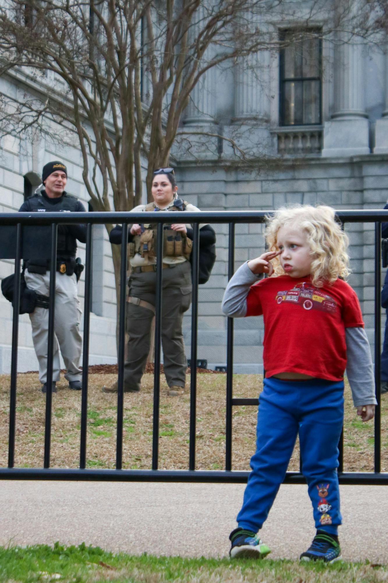 Law enforcement stayed on the inside of the fence, keeping watch over the remaining crowd of people attending Trump's first campaign stop on Jan. 28, 2023. The child (right) witnessed one of the few verbal altercations of the day.&nbsp;