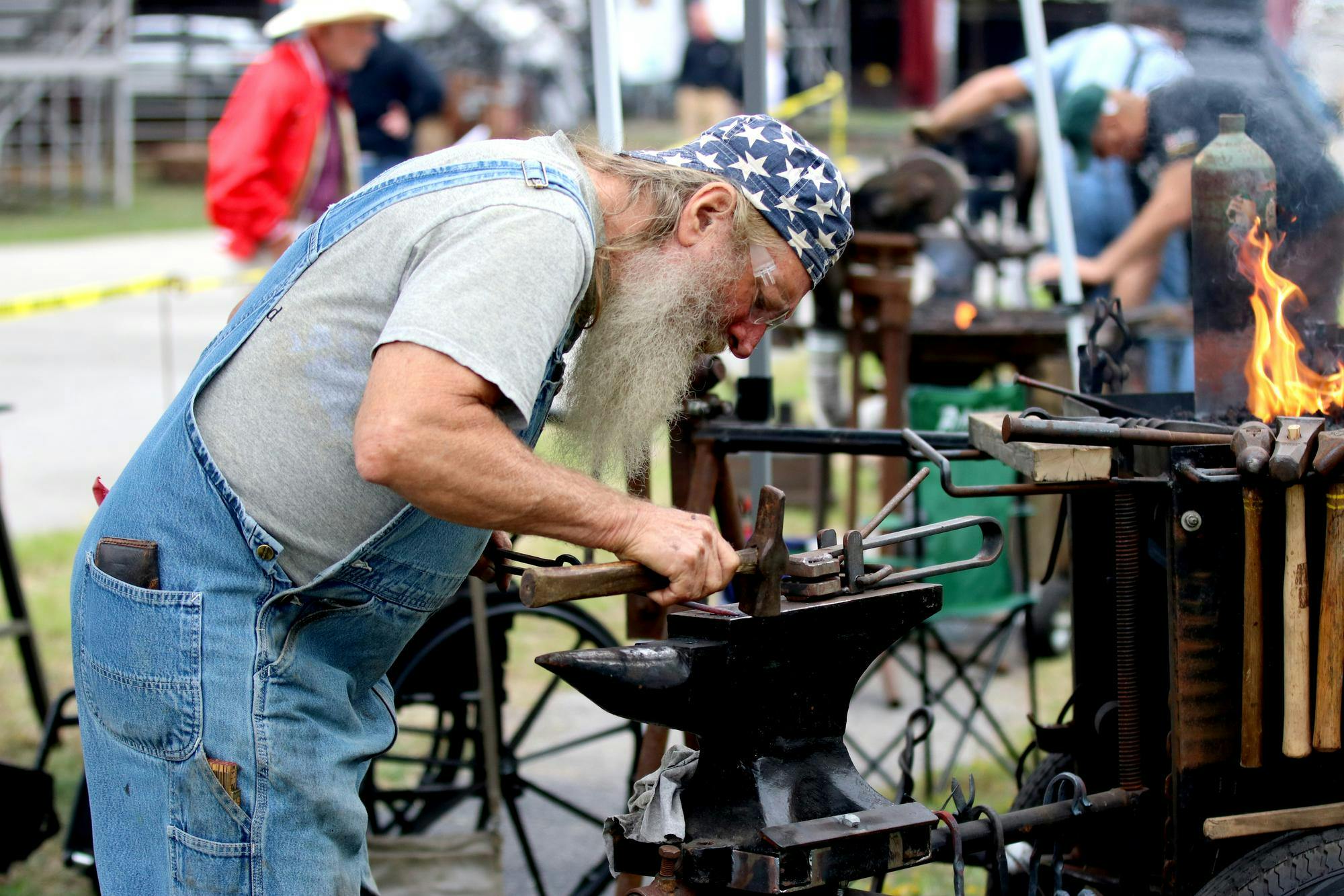 Tony Etheridge hammers the metal to get the right shape for his intended design at the Blacksmith Exhibition at the South Carolina State Fair on Oct. 10, 2025. Etheridge is a member of the Philip Simmons Blacksmith Guild.