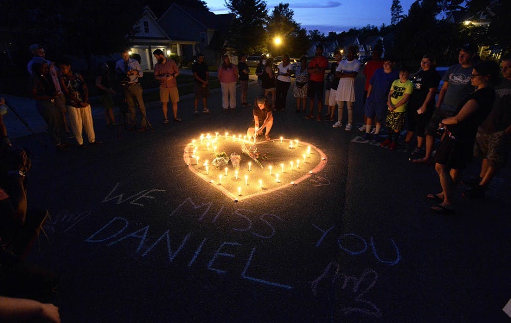 Friends and family of Daniel K. Harris gather around a heart drawn onto Seven Oaks Drive during a candlelight vigil on Monday, Aug. 22, 2016 to remember Harris, a deaf motorist who was shot and killed by a state trooper on Thursday, Aug. 18 in Charlotte, N.C. (David T. Foster III/The Charlotte Observer/TNS) 