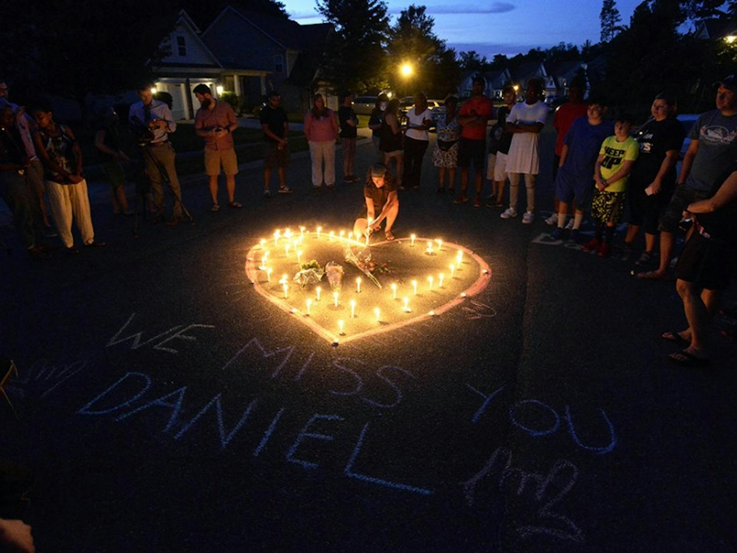 Friends and family of Daniel K. Harris gather around a heart drawn onto Seven Oaks Drive during a candlelight vigil on Monday, Aug. 22, 2016 to remember Harris, a deaf motorist who was shot and killed by a state trooper on Thursday, Aug. 18 in Charlotte, N.C. (David T. Foster III/The Charlotte Observer/TNS)