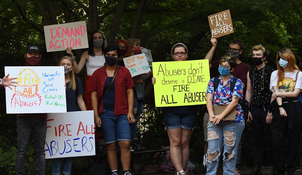 <p>Members of the Coalition to Fire David Voros display their signs outside of the Osborne Administration Building as part of its protest and march to urge the university to fire professors accused of sexual misconduct.</p>