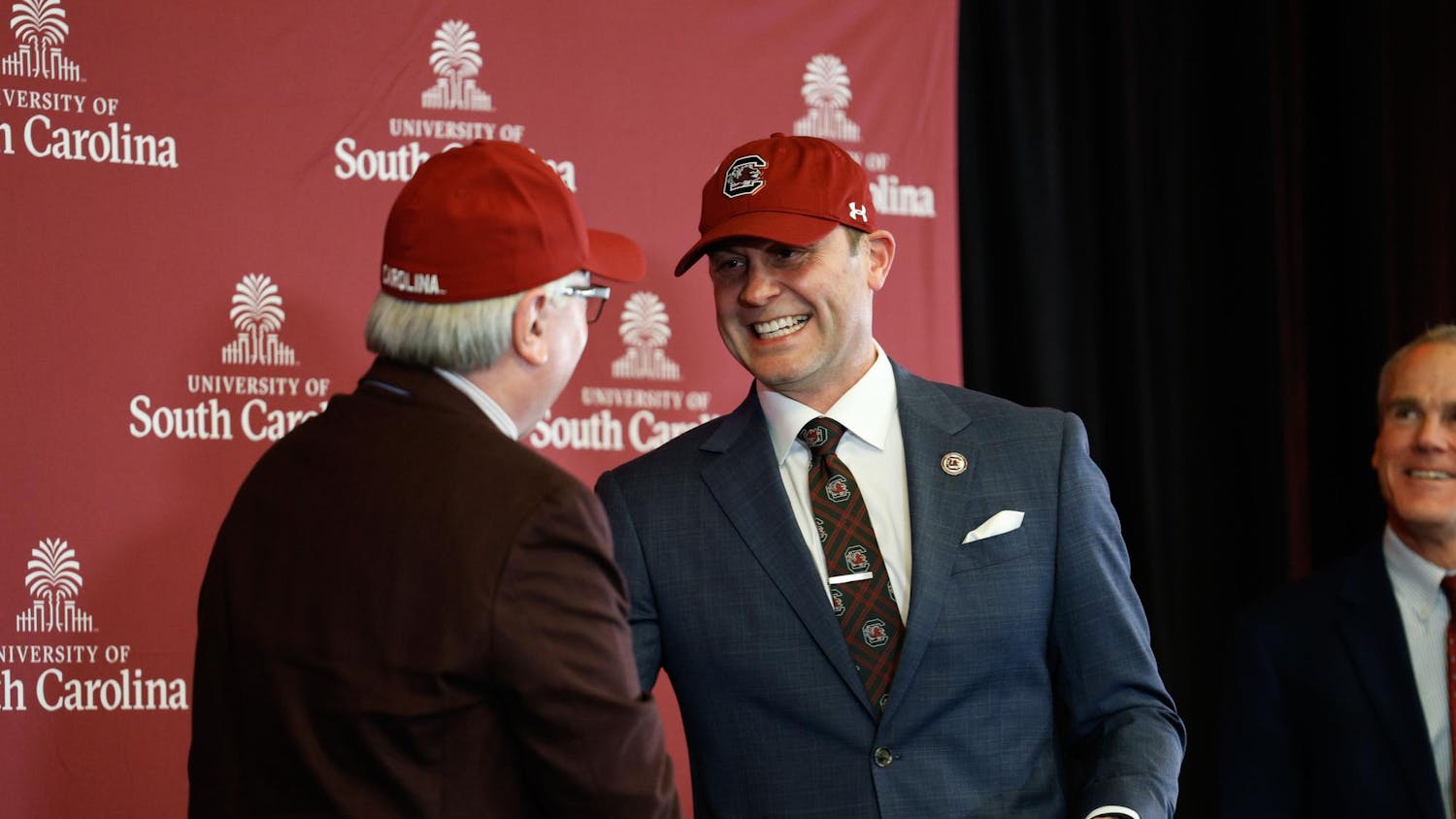 New South Carolina Athletics Director Jeremiah Donati shakes hands with USC President Michael Amiridis after a press conference at The Zone on Dec. 5, 2024. Donati is interested in better engaging with the student body and driving revenue.