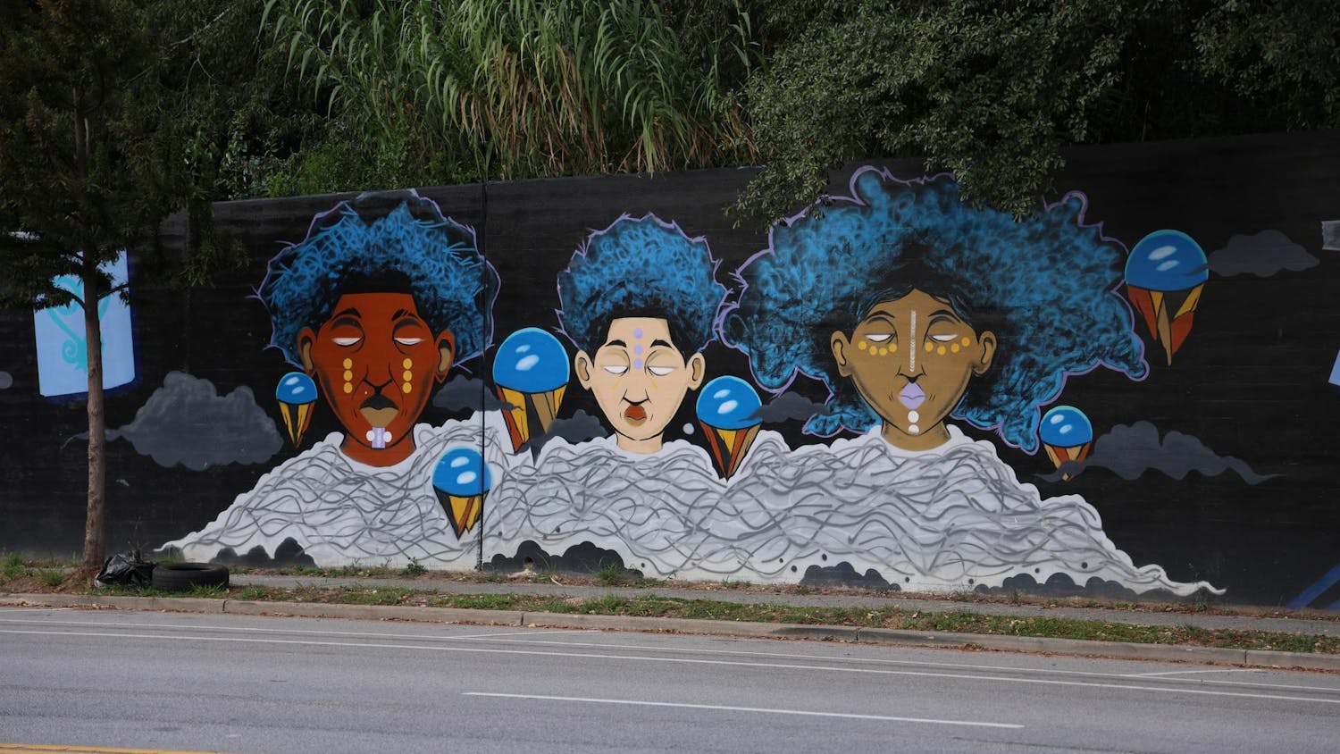 A triptych mural sits on Millwood Avenue on Sept. 16, 2025. The mural was created by Karl Zurfluh, Brandon Donahue and Cedric Umoja.