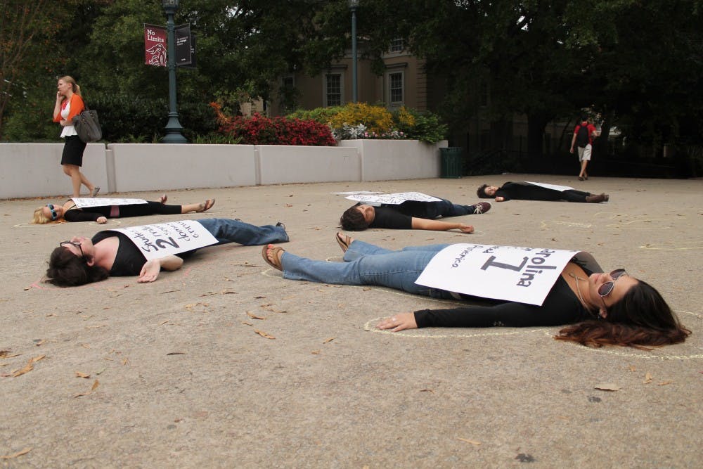 	<p>Die-In participants lay down on the Pickens Street Bridge on Monday to raise awareness of domestic violence.</p>