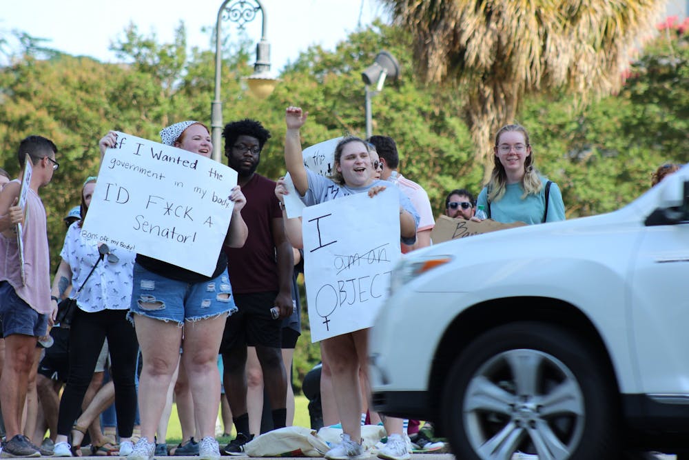 <p>Demonstrators cheer and hold signs in front of the Statehouse on June 24, 2022. The protest comes after the Supreme Court ruled to overturn Roe v. Wade.&nbsp;</p>