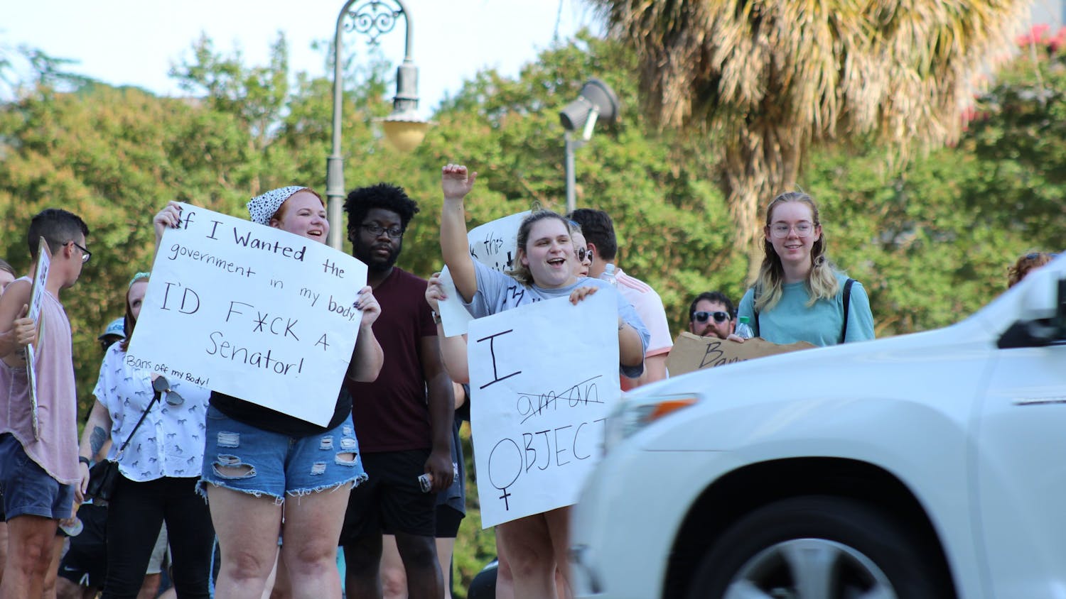 Demonstrators cheer and hold signs in front of the Statehouse on June 24, 2022. The protest comes after the Supreme Court ruled to overturn Roe v. Wade.&nbsp;