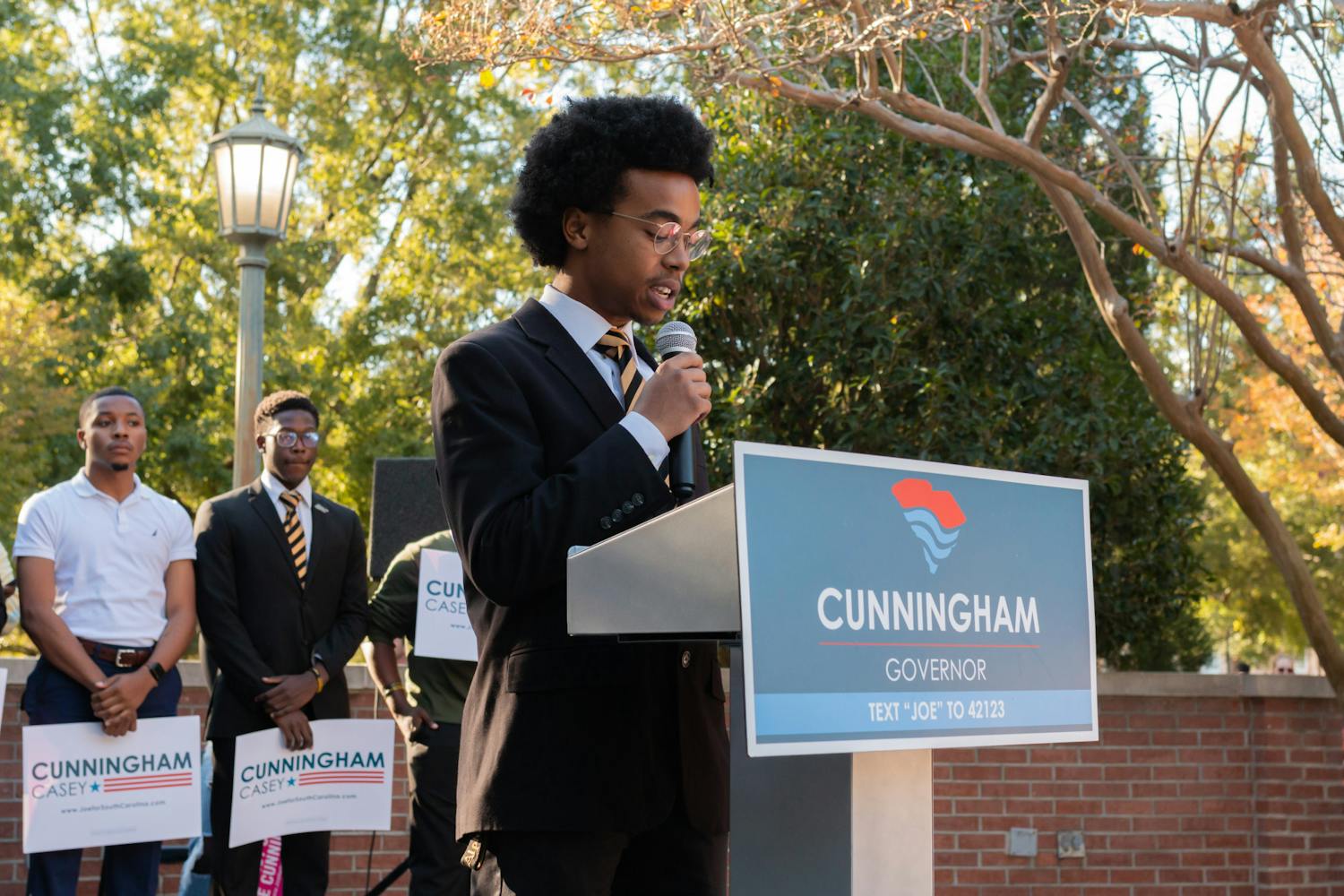Tre Harris of the Theta Nu Chapter of Alpha Phi Alpha Fraternity, Inc. takes to the podium on Oct. 20, 2022, to speak to spectators during a Joe Cunningham rally. Harris and other students shared their views with the crowd at the Russell House Patio without specifically endorsing a particular nominee.  