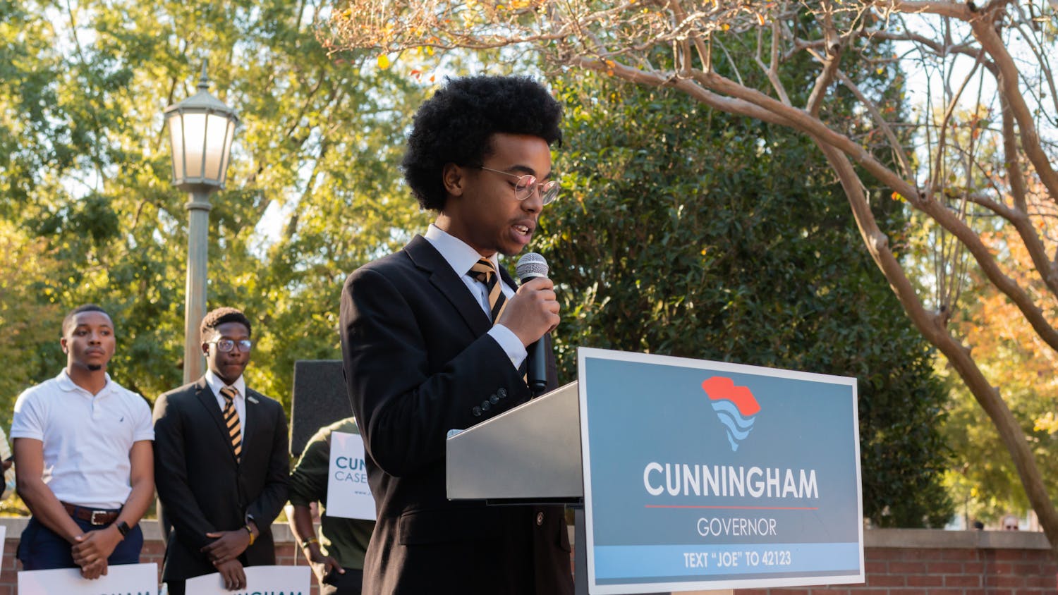 Tre Harris of the Theta Nu Chapter of Alpha Phi Alpha Fraternity, Inc. takes to the podium on Oct. 20, 2022, to speak to spectators during a Joe Cunningham rally. Harris and other students shared their views with the crowd at the Russell House Patio without specifically endorsing a particular nominee.  