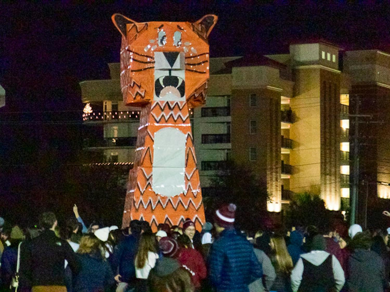 The 30-foot tall, orange and white, Clemson Tiger statue towers over a large crowd of USC students on Nov. 21, 2022. The tiger was constructed in the middle of the Bluff Road Intermural field by the USC American Society of Mechanical Engineers and Society of Hispanic Professional Engineers constructed the effigy for this year's event.