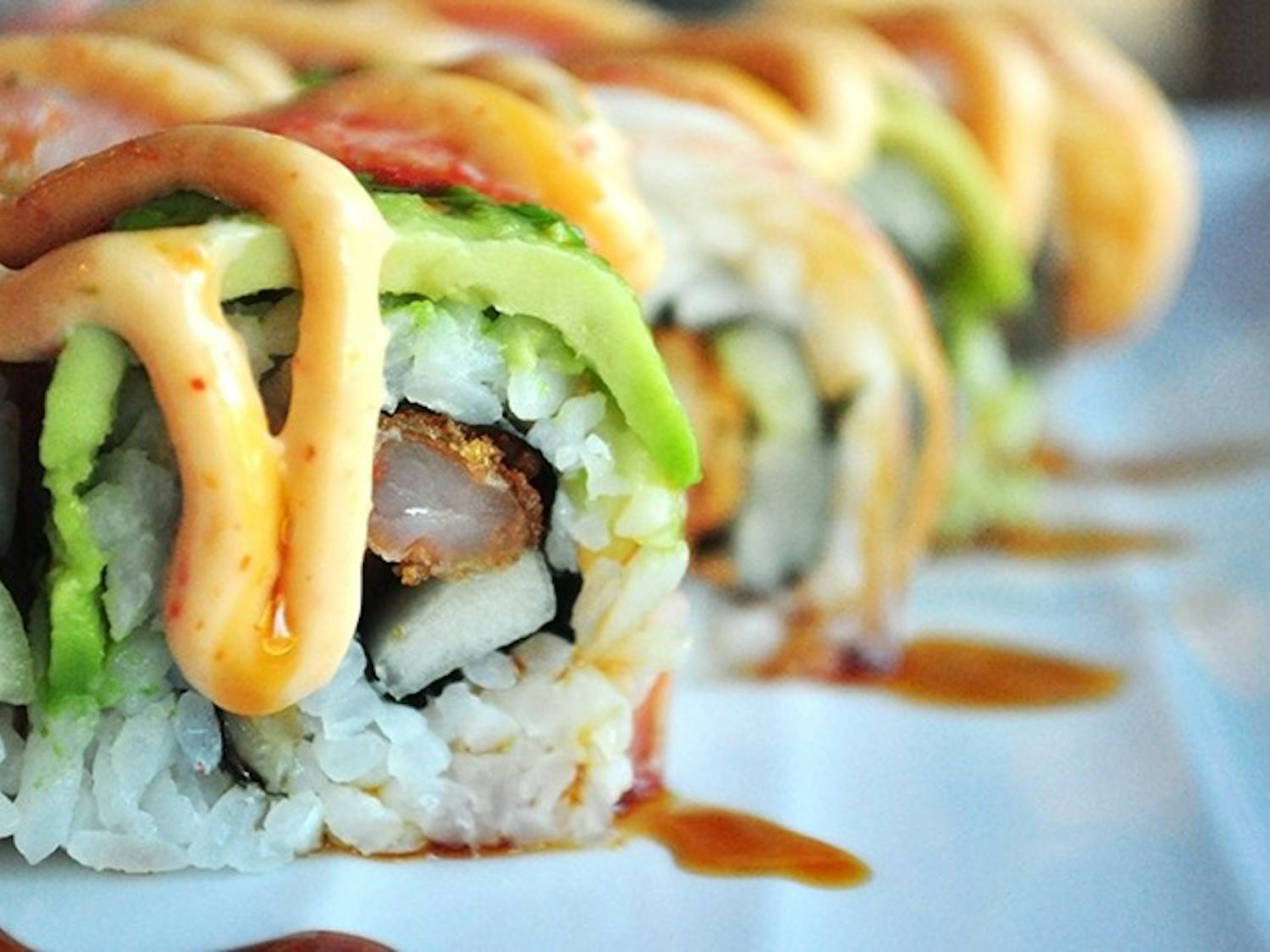 The dragon roll is a combination of crunchy shrimp, avocado, cucumber, and Takosushi sauce with teryaki glaze.