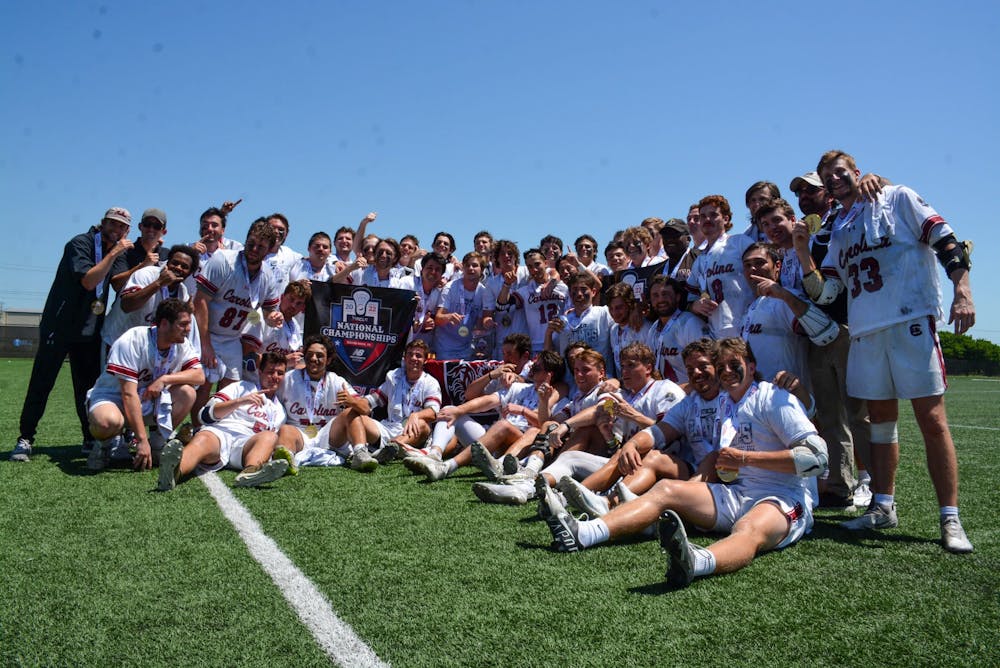 <p>South Carolina's club lacrosse team poses with medals and a banner after winning the national championship on May 14, 2022. The team beat Georgia Tech in an 11-9 victory.&nbsp;</p>