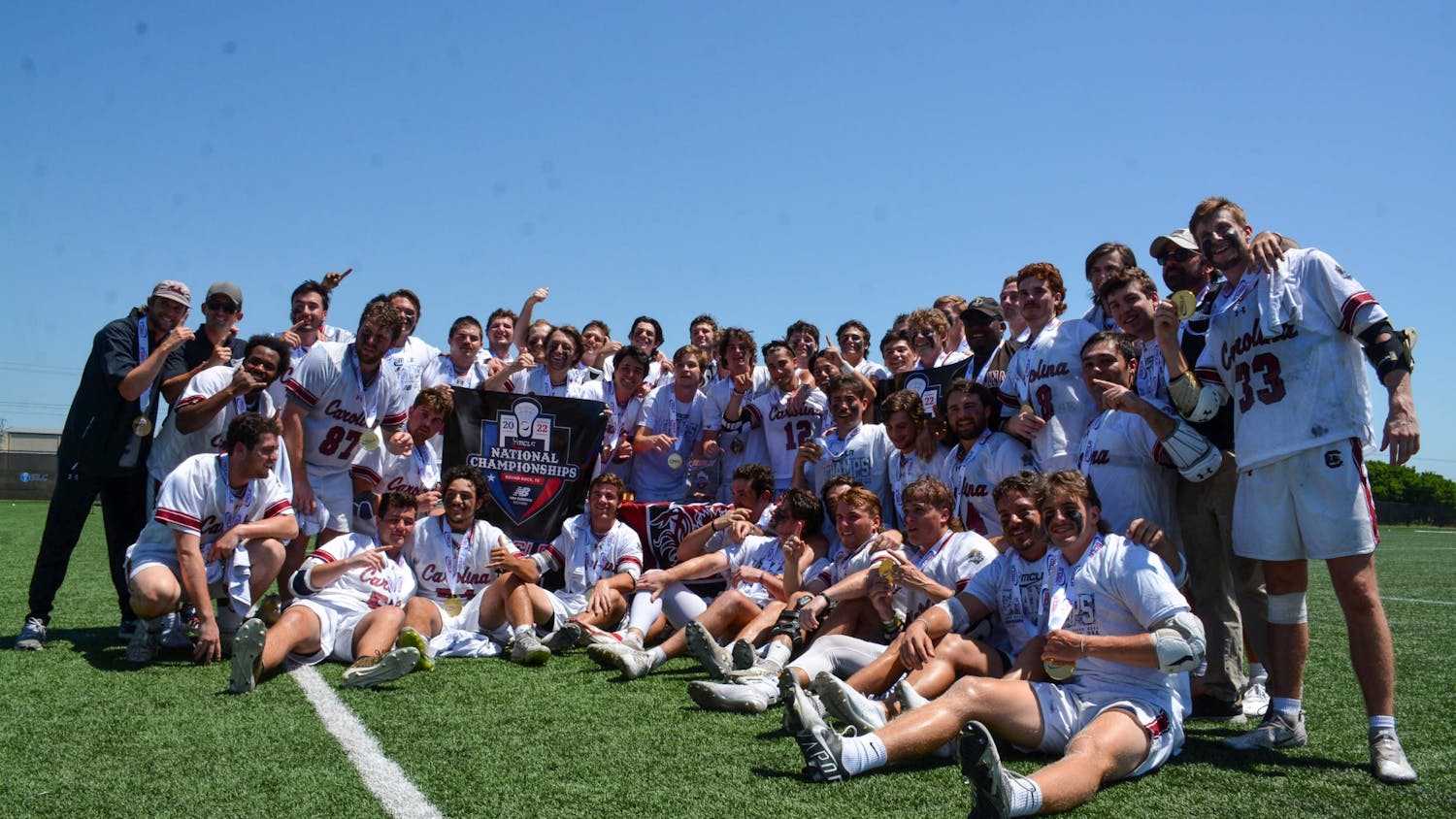 South Carolina's club lacrosse team poses with medals and a banner after winning the national championship on May 14, 2022. The team beat Georgia Tech in an 11-9 victory. 