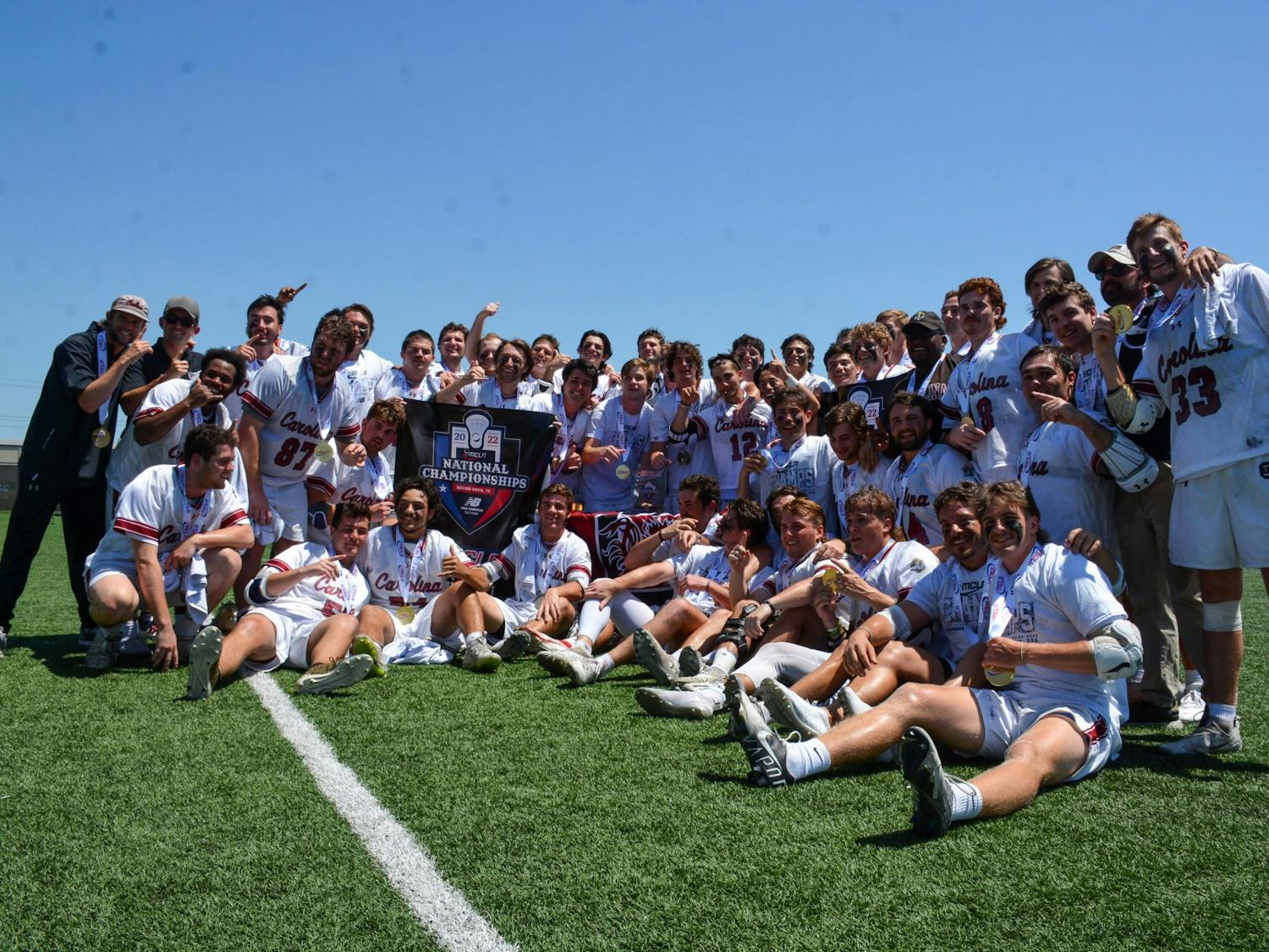 South Carolina's club lacrosse team poses with medals and a banner after winning the national championship on May 14, 2022. The team beat Georgia Tech in an 11-9 victory. 