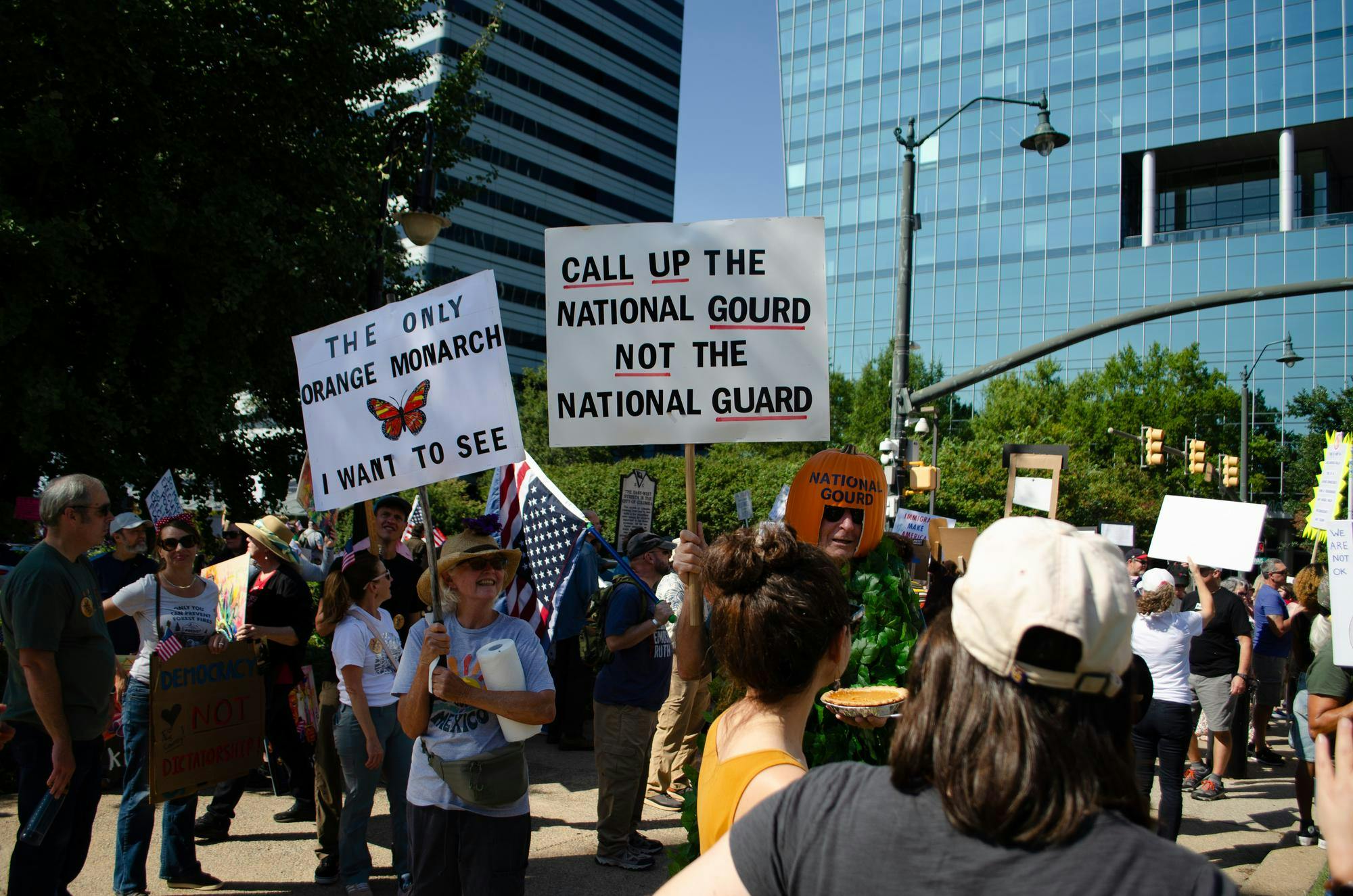 A protester wearing a pumpkin on his head refers to himself as the "National Gourd" at a "No Kings" protest in Columbia, South Carolina on Oct. 18, 2025. He offers pumpkin pie to other protesters and holds a sign that says, "Call up the National Gourd not the National Guard."