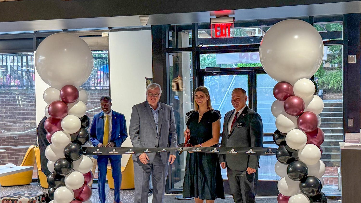 Student Body President Courtney Tkacs (center) cuts a ceremonial ribbon commemorating the opening of Garnet Station on Aug. 14, 2025, alongside University President Michael Amiridis (left) and Carolina Food Co. District Manager Clete Myers (right). Garnet Station is a new "all-you-care-to-eat" dining hall in the first floor of Russell House, next to the bookstore.