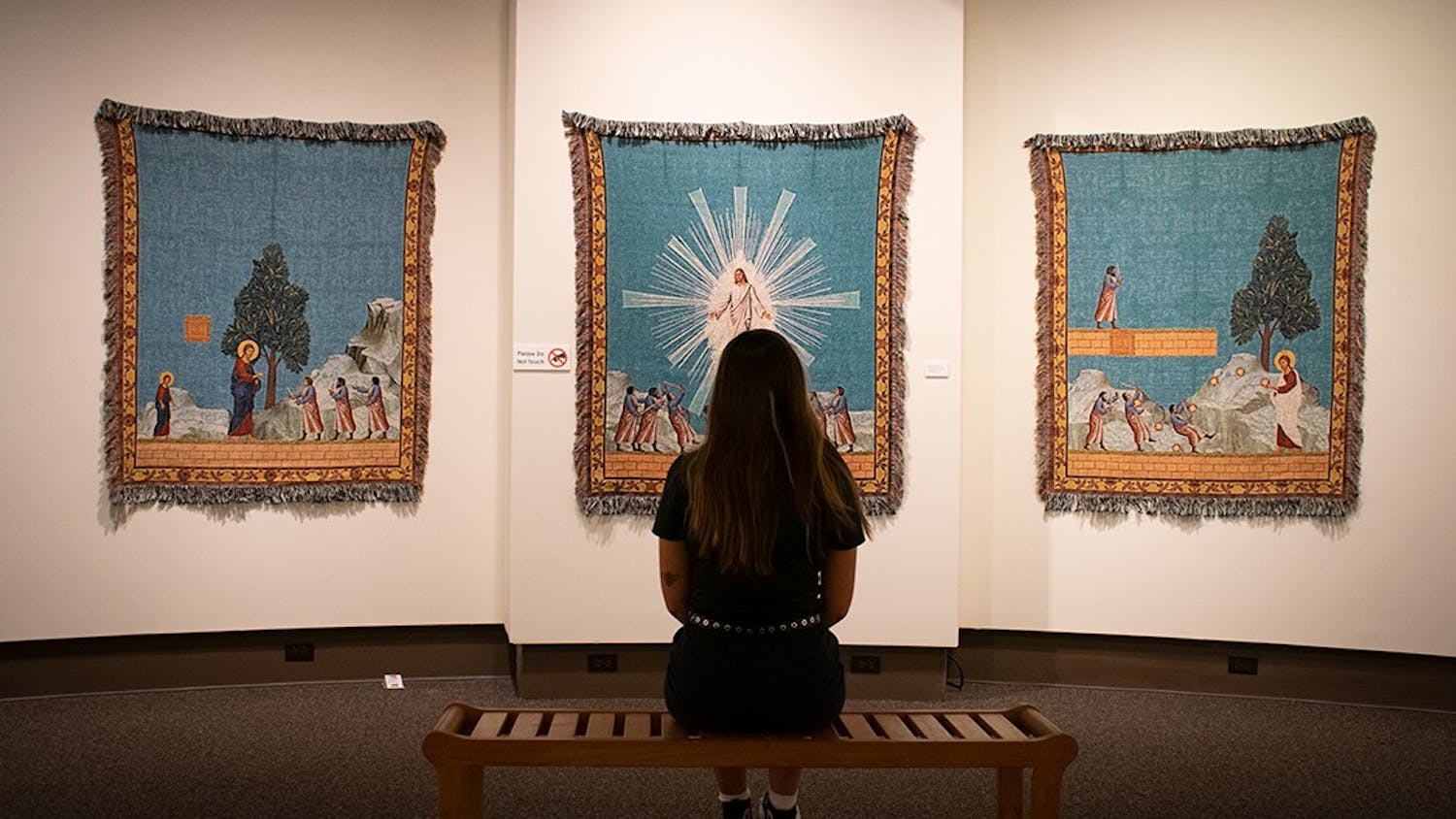 A museum-goer observes “Hyphen-ated," an art exhibit in the McKissick Museum. The works of Dan Hernandez and Arturo Rodriguez incorporate ideas of race religion and pop-culture.