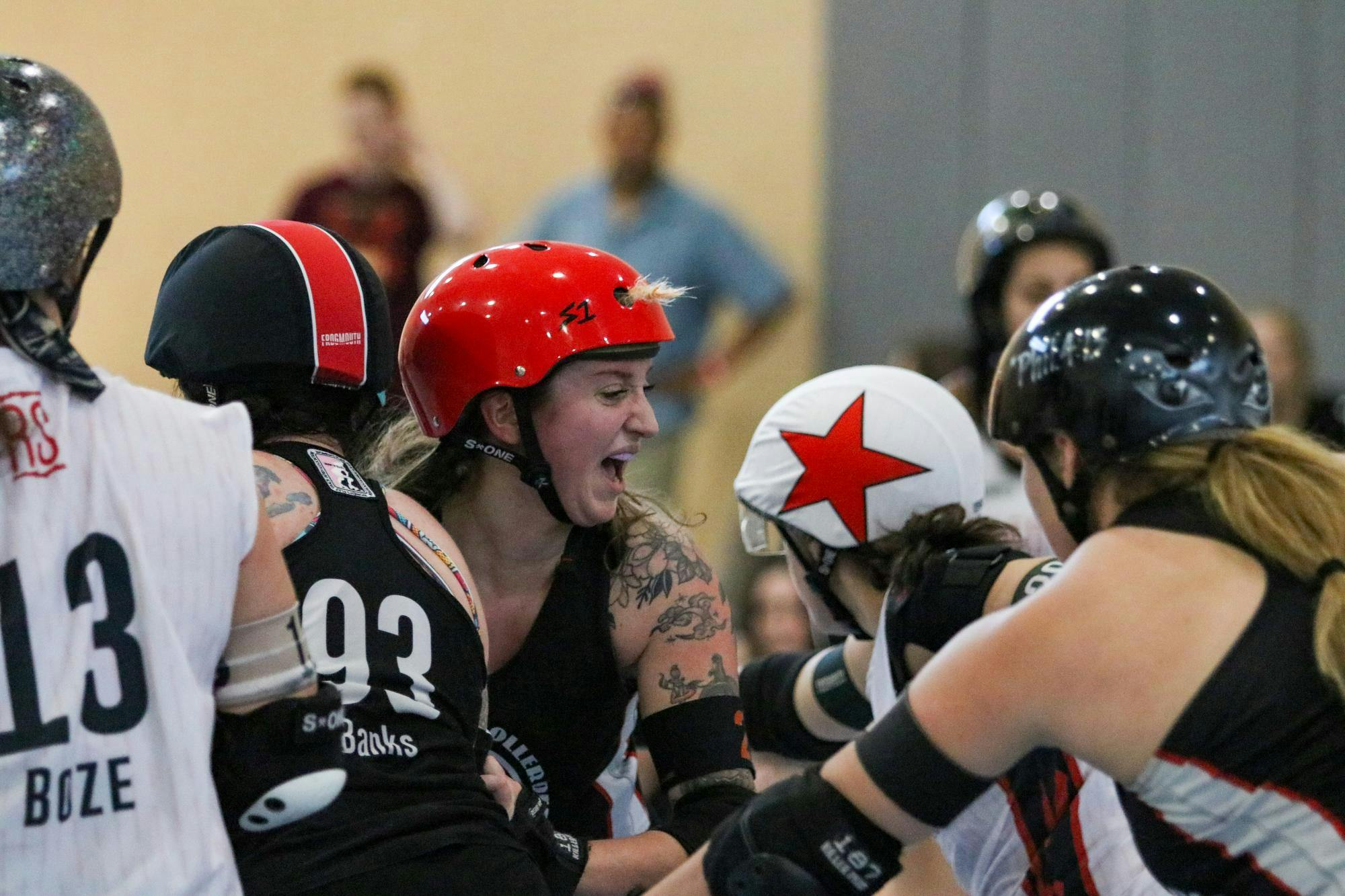 Columbia Roller Derby skater Stella “Valentina Massacre” Redner shouts at her team as they block opposing Red Stick All Star skaters on March 22, 2026, at St. Andrews Park. When a skater is pushed out of bounds in roller derby, they must re-enter behind everyone who was in front of them at the moment of exit. “Feeling a little hot, a little sweaty, and I’m saying ‘out’ really loud because we were about to lose it on the out,” Redner said.