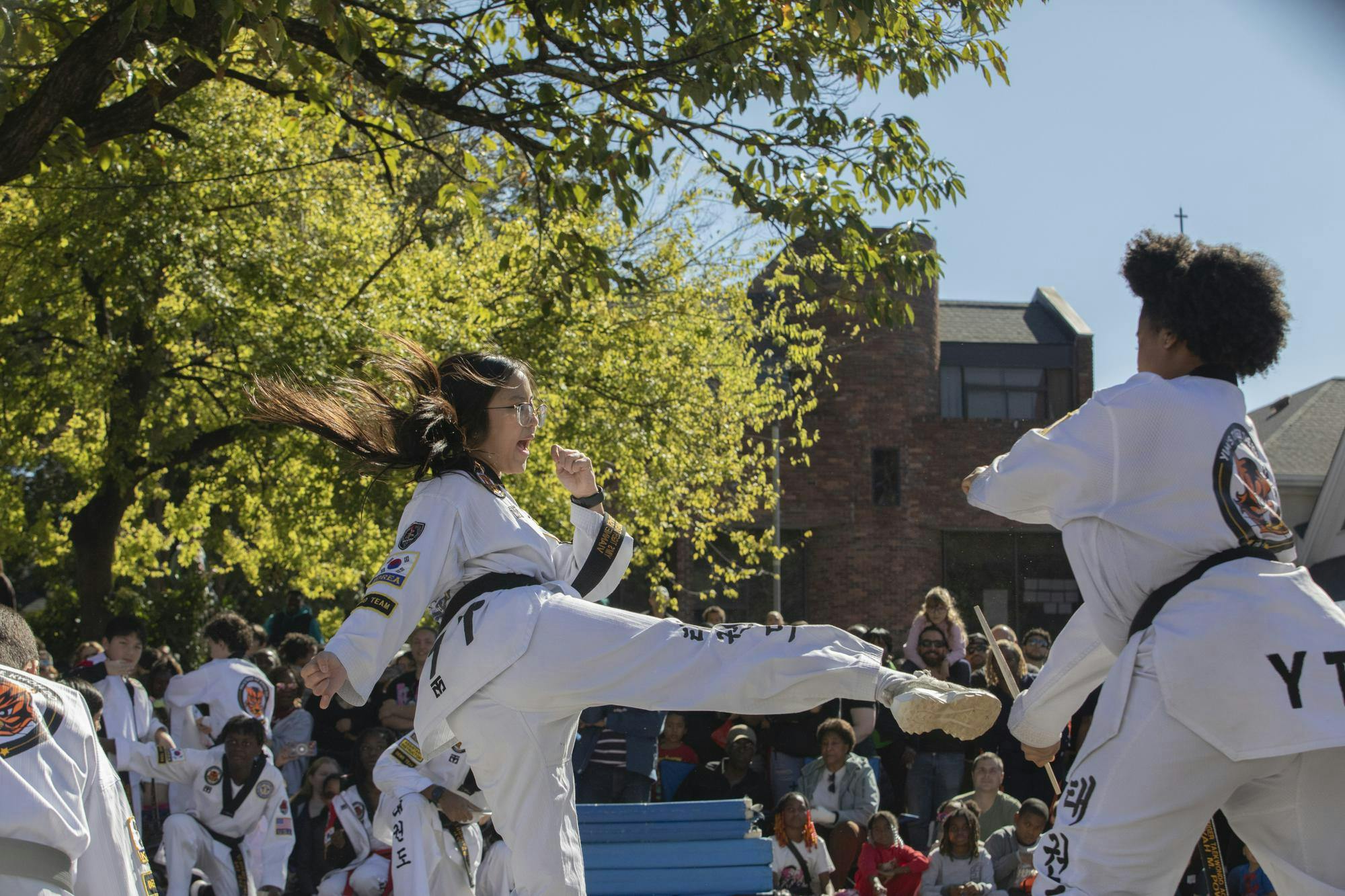 A student of Yin’s Tiger Taekwondo prepares to break a wood panel at the Korean Festival on Nov. 1, 2025, on Richland Street. The academy’s performance exhibited a wide array of talents such as chopping cinder blocks in half, wielding a katana, summersaults and more.