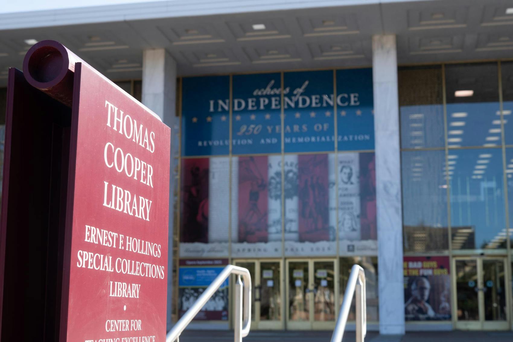 A library with a sign in front of the building with the words "Thomas Cooper Library."